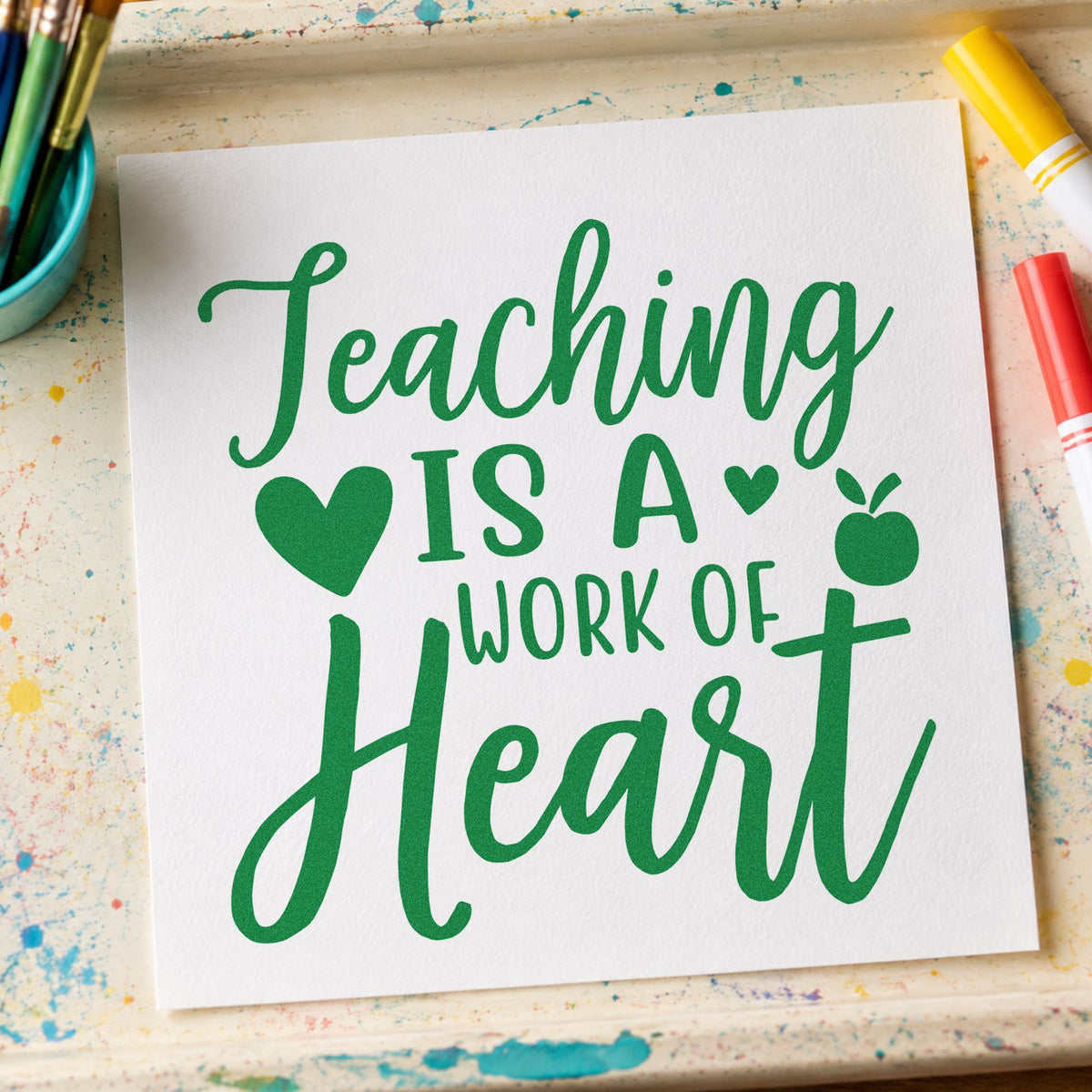 Teaching Is Work Of Heart craft stamp imprint in green ink on a handmade project, one idea being portfolio cover pages.