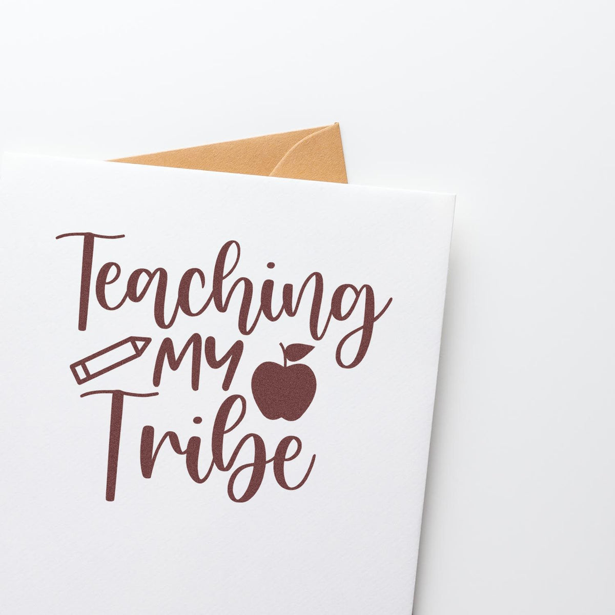 Maroon teacher stamp seal on white card with tan envelope, reading Teaching My Tribe with pencil and apple icons.