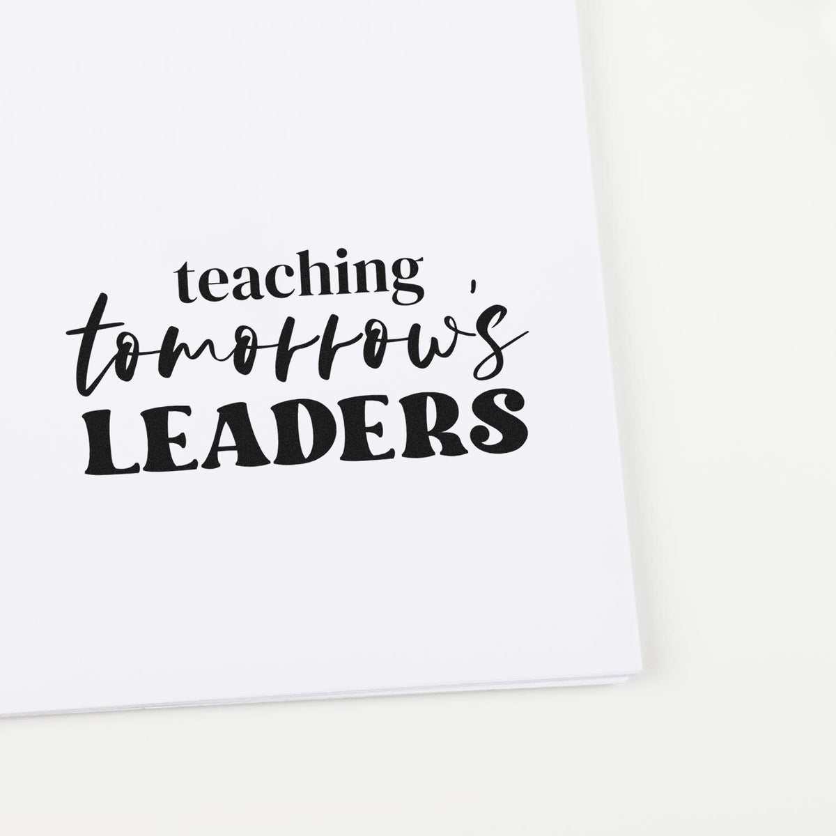 Black teaching stamp seal with teaching tomorrows LEADERS in black on white paper