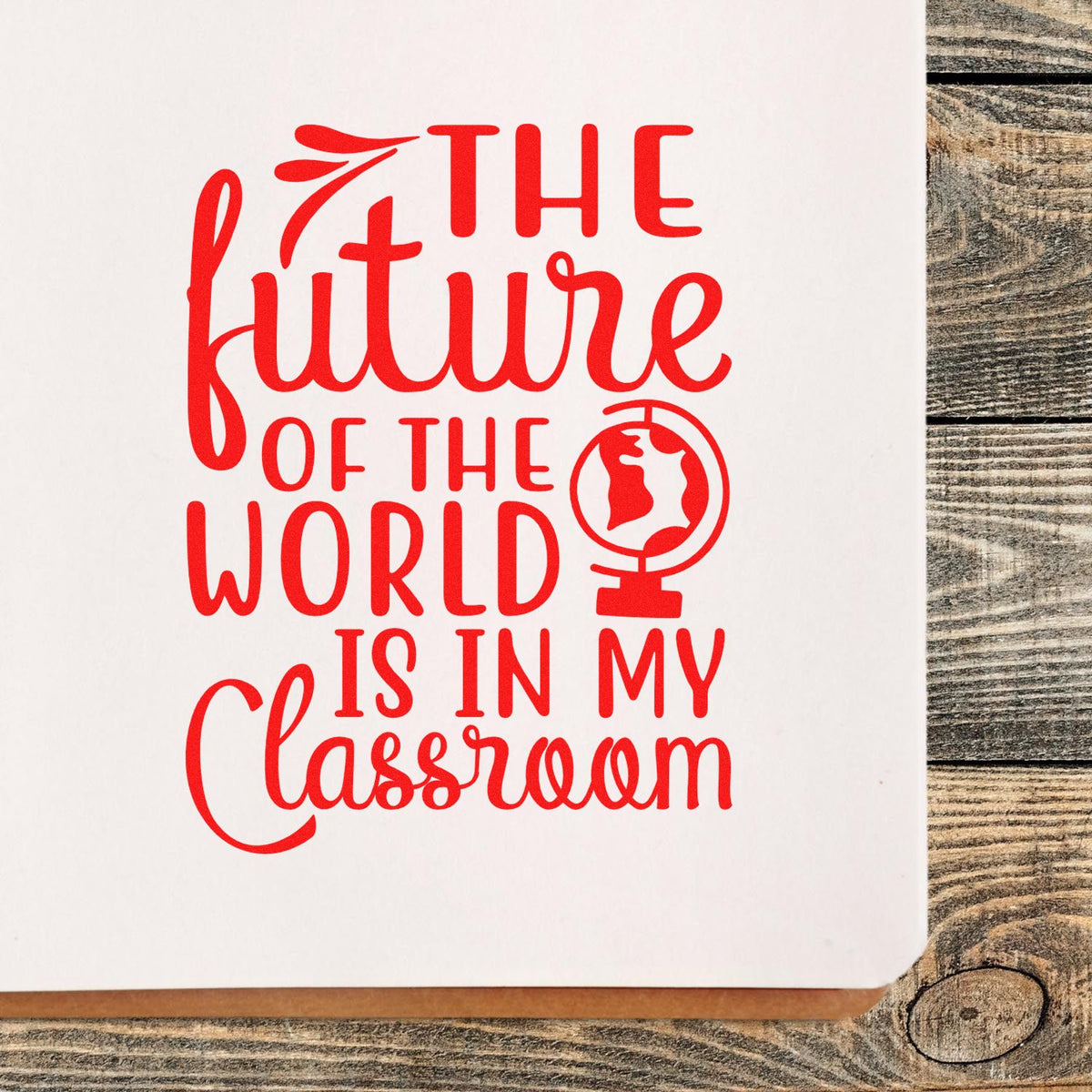 Red classroom stamp reading The future of the world is in my classroom with globe icon on white paper.