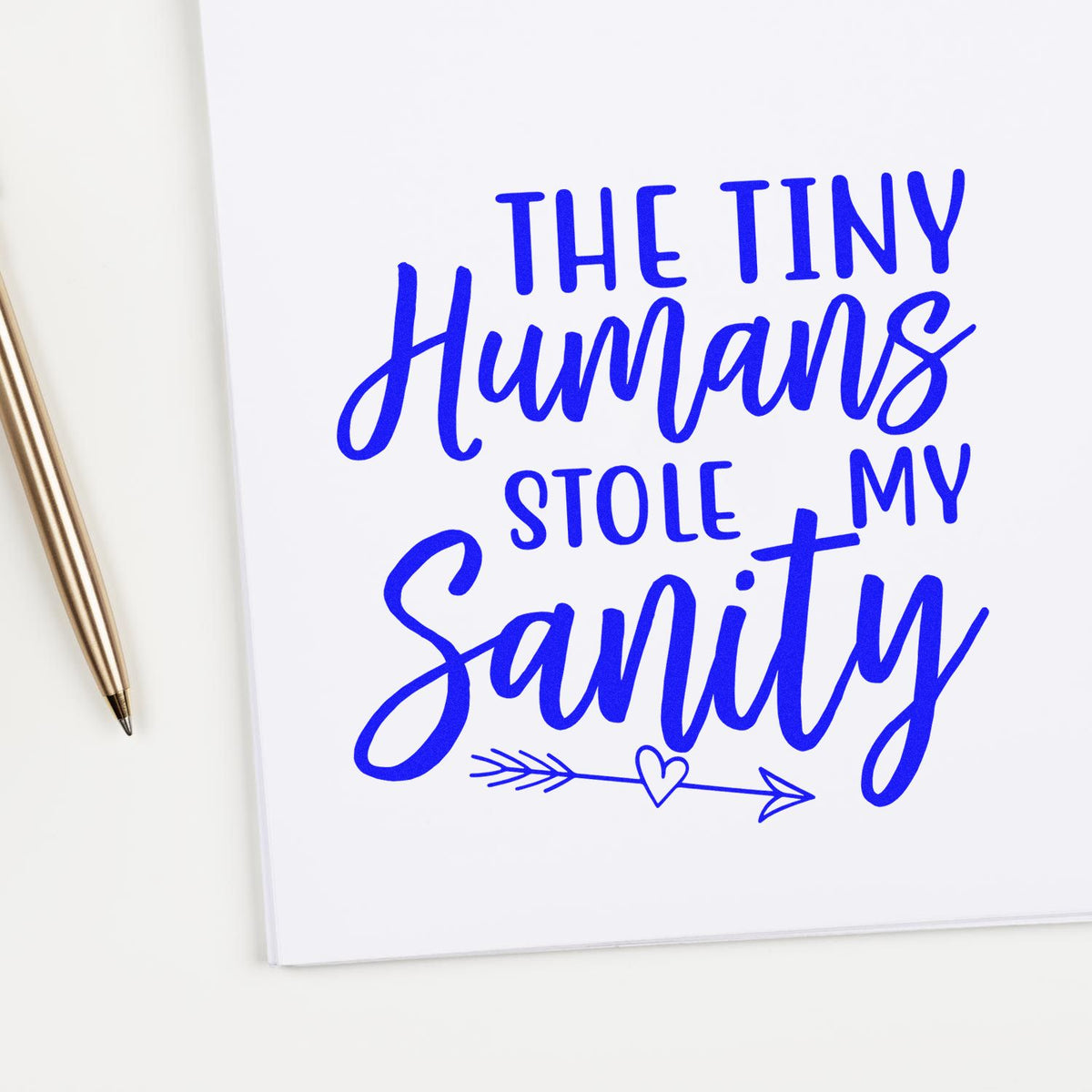 White card with bright blue stamp-style text, The Tiny Humans Stole My Sanity, plus a heart arrow and gold pen.