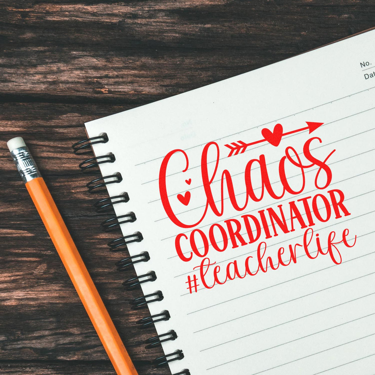Red Chaos Coordinator #teacherlife stamp seal on lined spiral notebook with orange pencil on dark wood background.