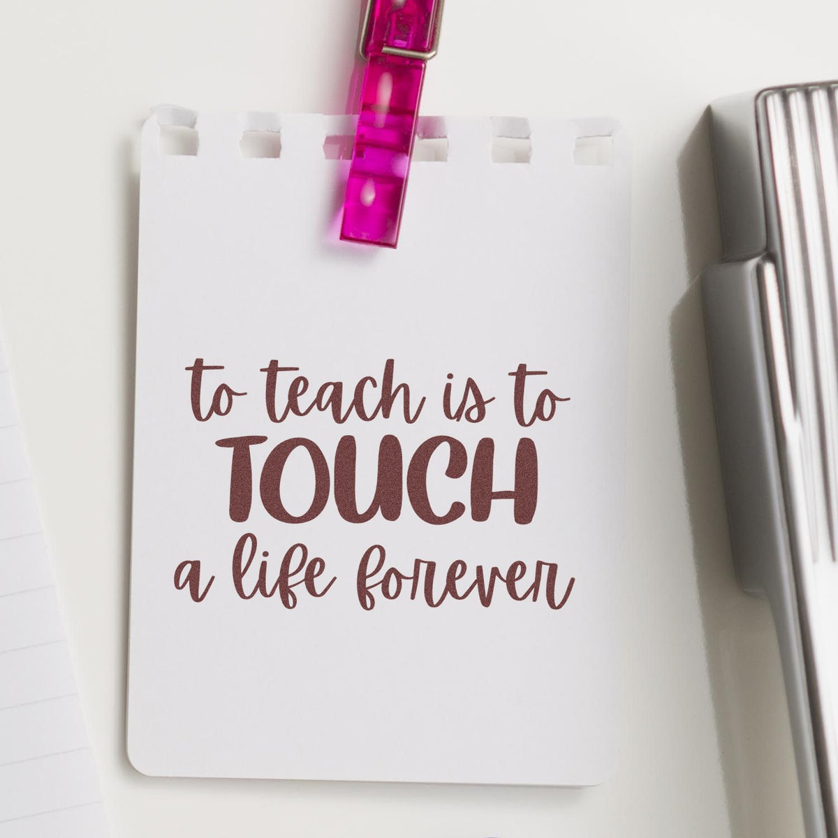 White stamp-and-seal card with maroon to teach is to TOUCH a life forever quote, pink clip, and silver seal.