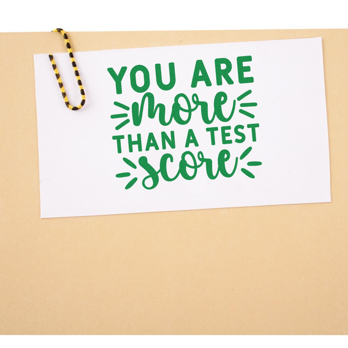 More Than Test Score rubber stamp shown in green ink, stamped for projects such as exam kit tags.