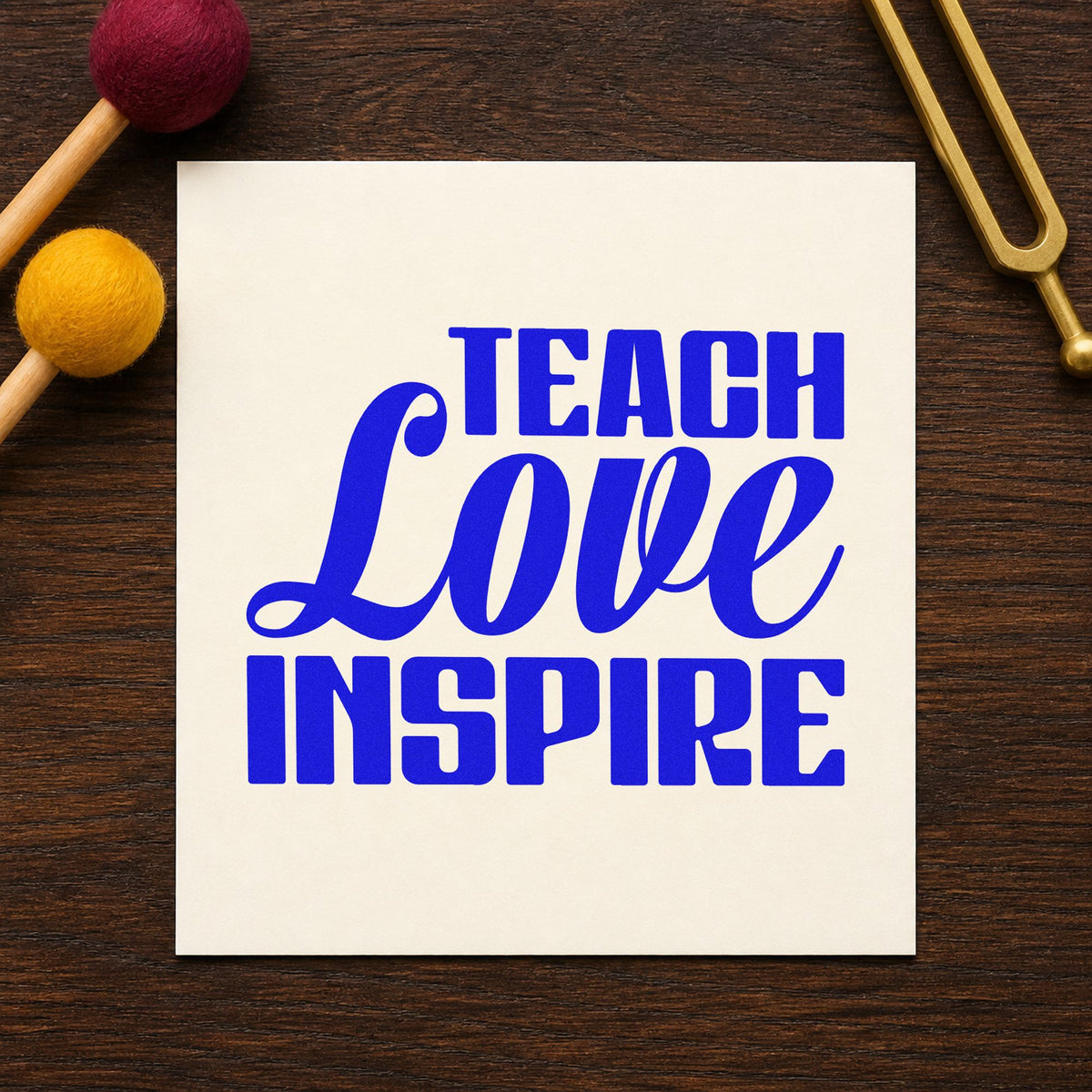 Teach Love Inspire Bold Script craft stamp imprinted in blue ink on paper, a design suited to place setting seals.