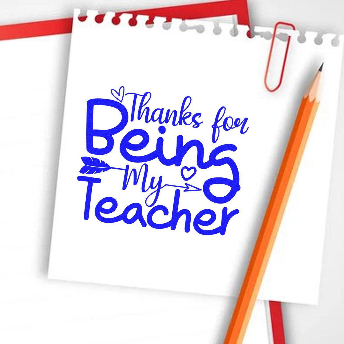 Blue "Thanks for Being My Teacher" stamp/seal on white notebook paper, with red paperclip and orange pencil.