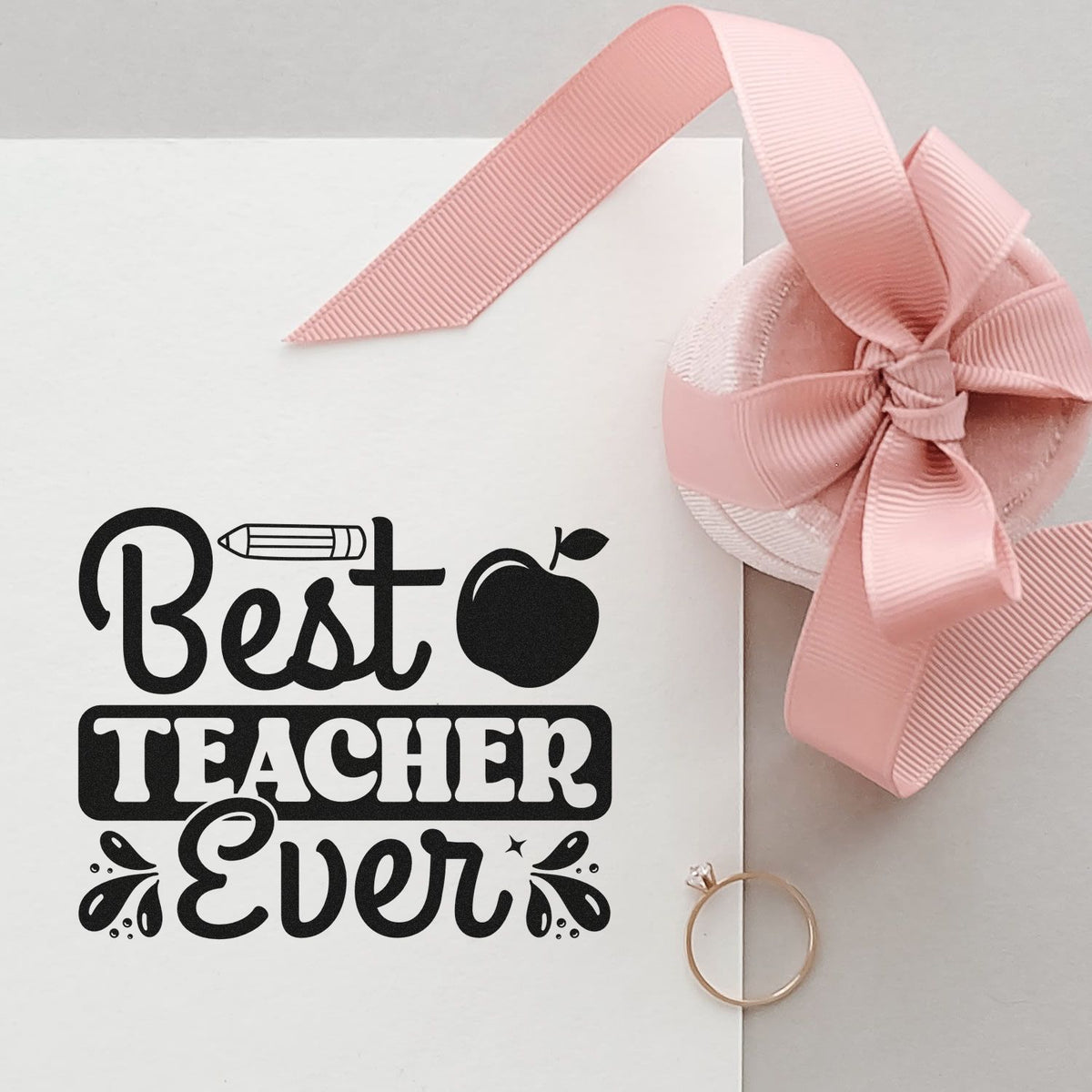 Black Best Teacher Ever stamp and pink ribbon wax seal on white card with pencil and apple icons.