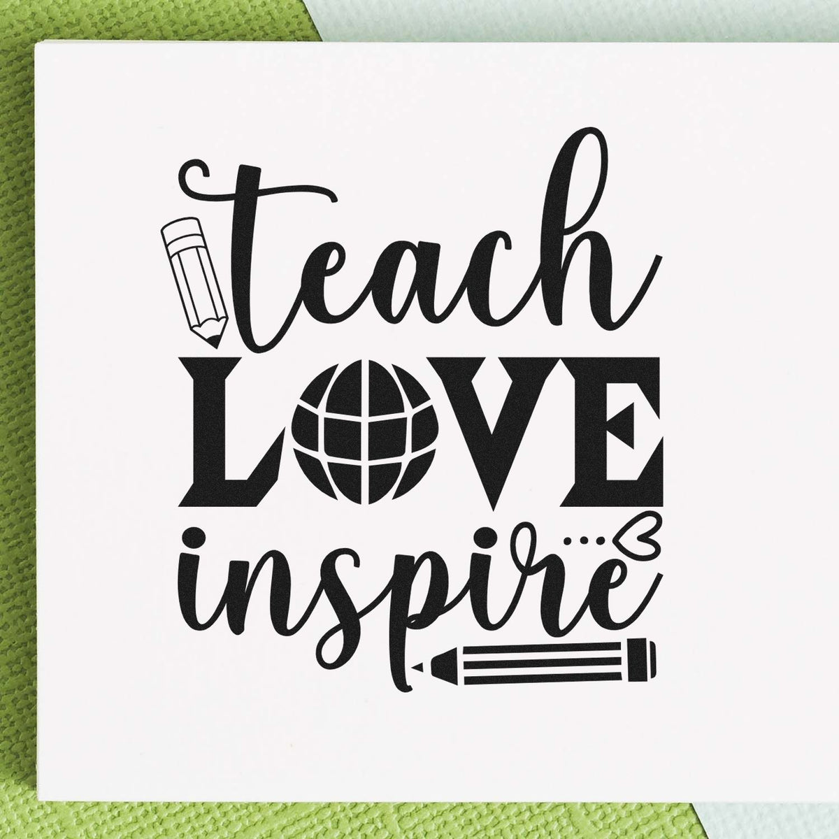 Black teacher stamp and seal design with Teach Love Inspire, pencil and globe icons on white paper.
