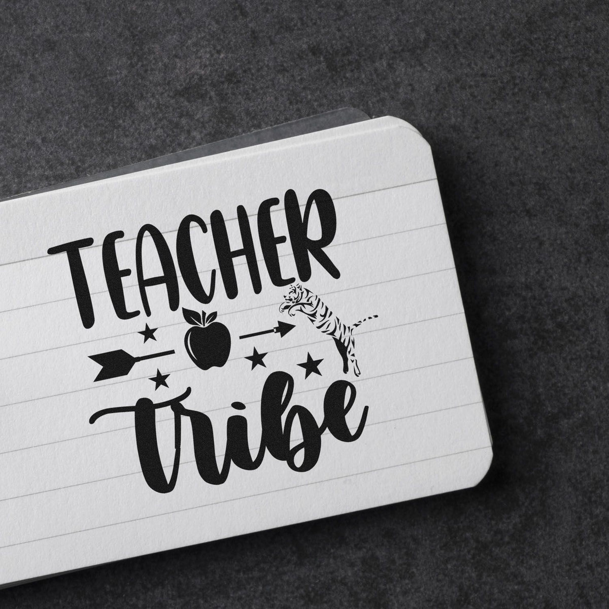 Black teacher tribe stamp seal on white lined card, with apple, stars, arrows, and tiger graphic.