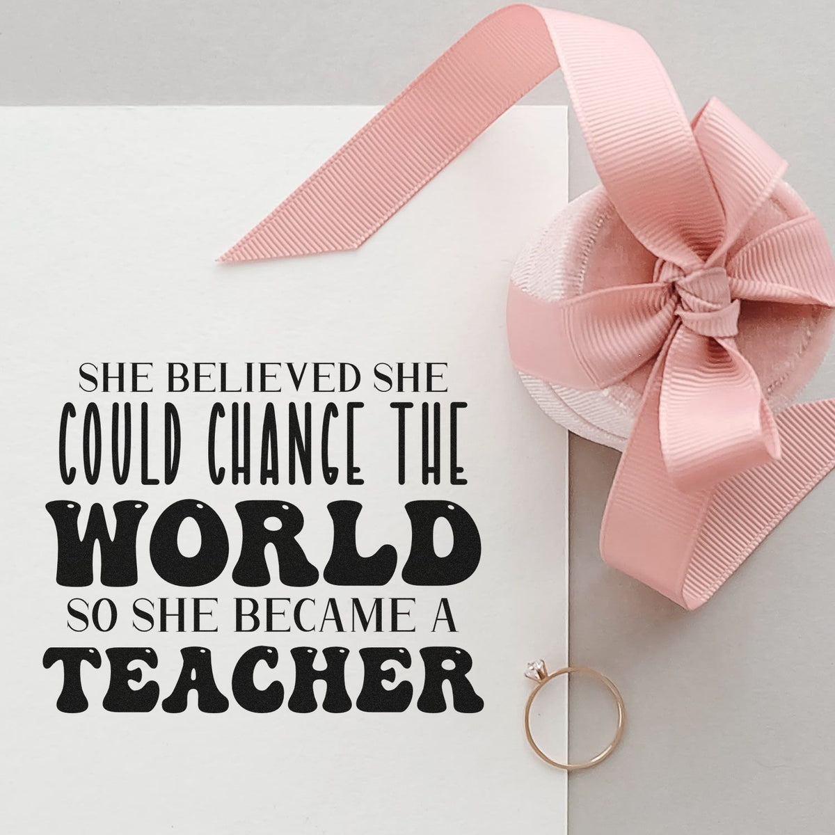 Teacher stamp and pink ribbon wax seal on white card, with black motivational quote and gold ring