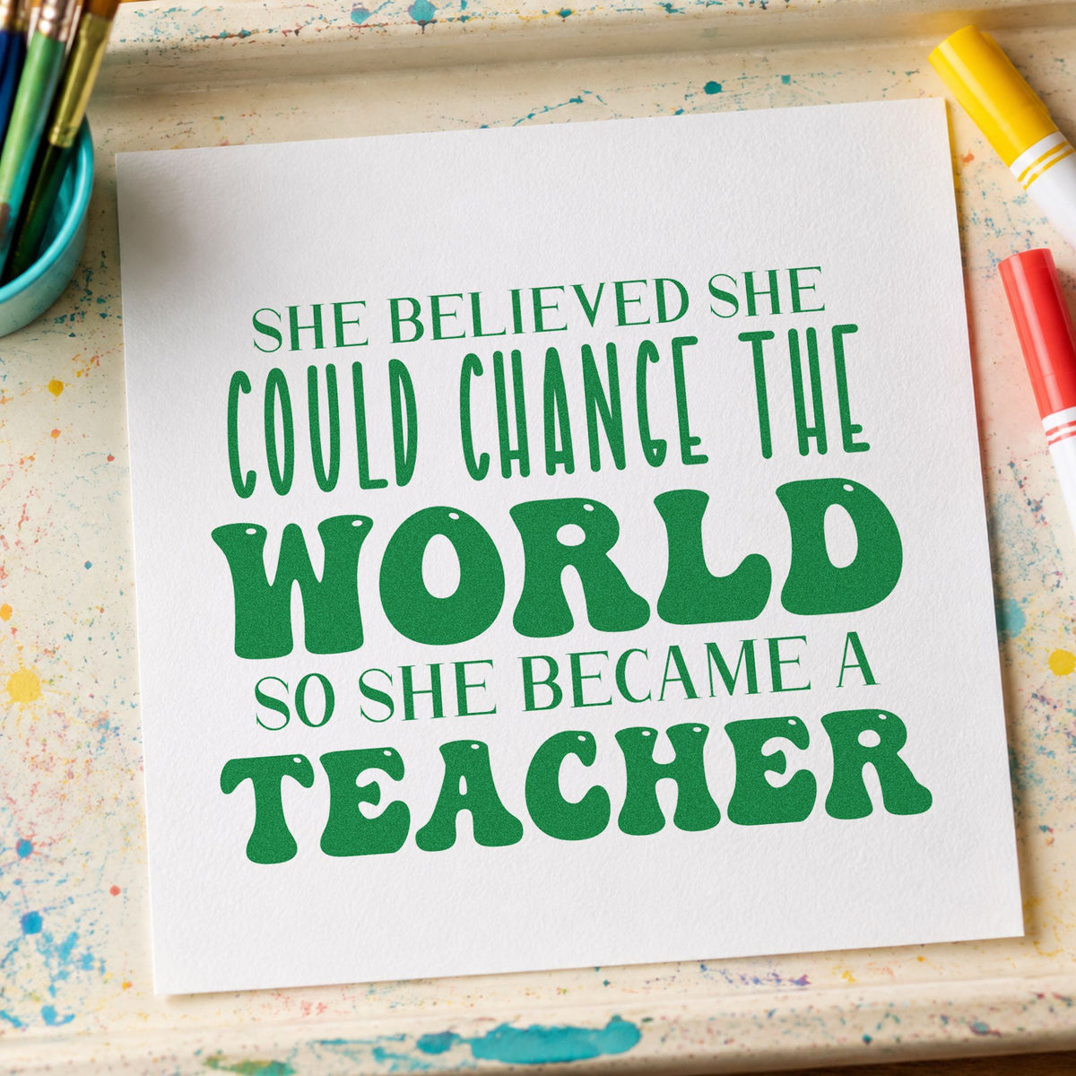 She Became A Teacher craft stamp imprint in green ink on a handmade project, one idea being application pages.