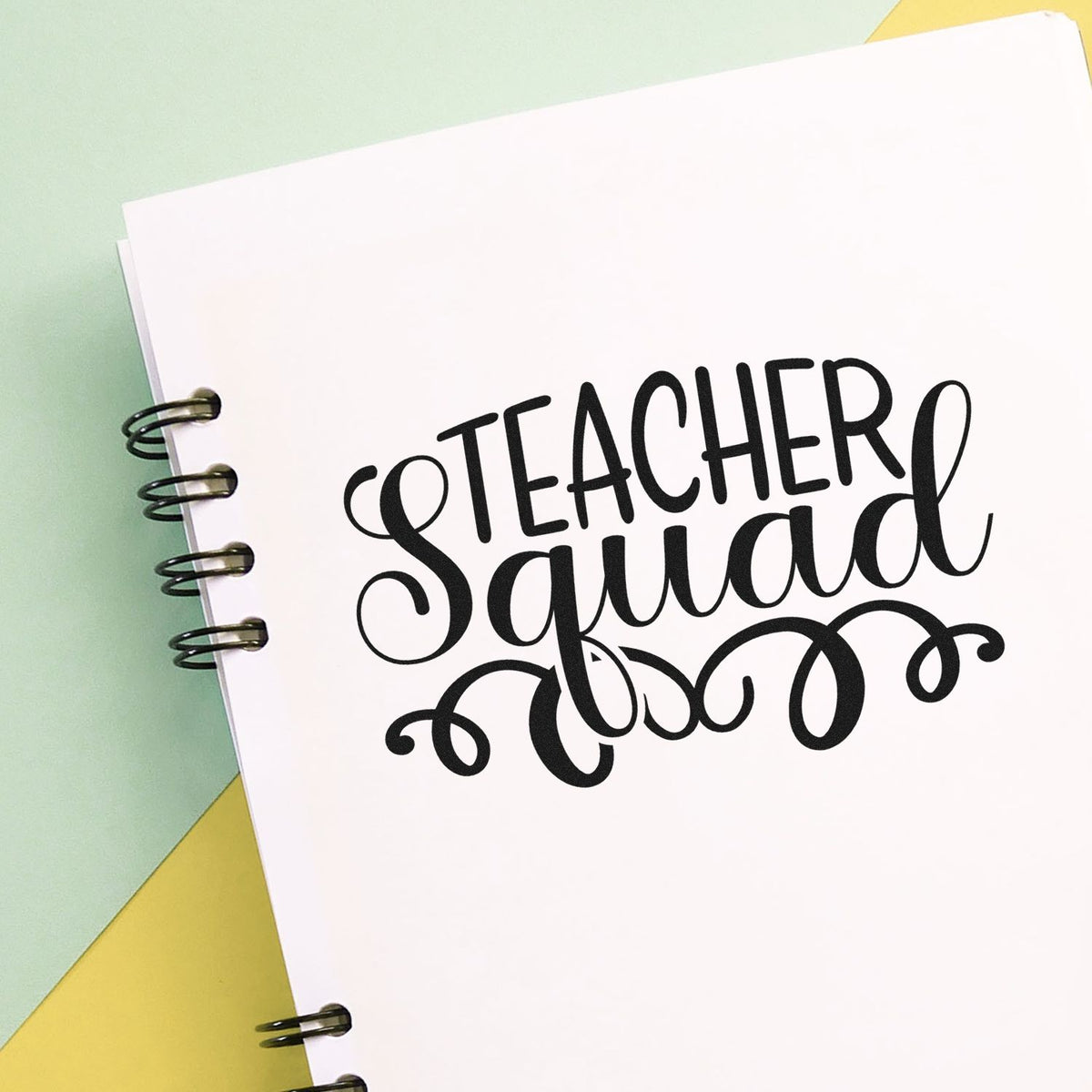 Black Teacher Squad stamp and seal design on a white spiral notebook, with mint green and yellow background.