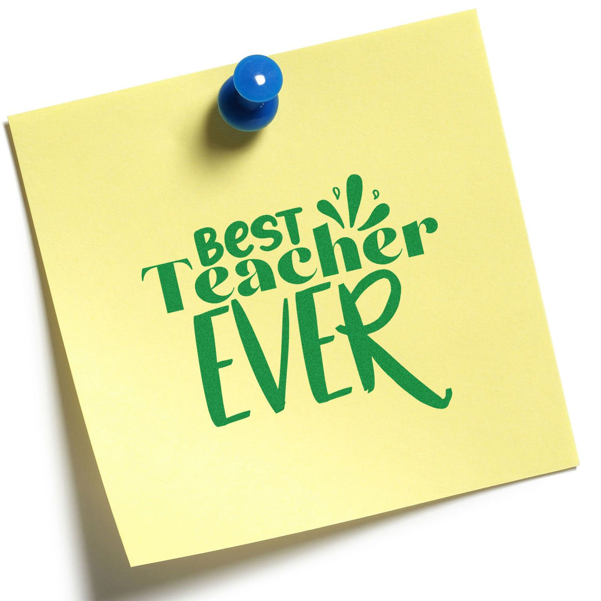 Green Best Teacher Ever stamp seal on a yellow note, pinned with a blue pushpin.