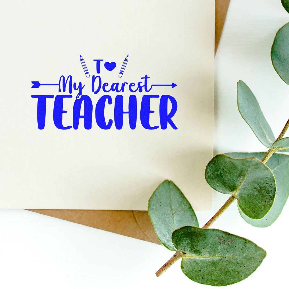Blue To My Dearest Teacher stamp on cream paper, with eucalyptus leaves and a kraft envelope seal background.