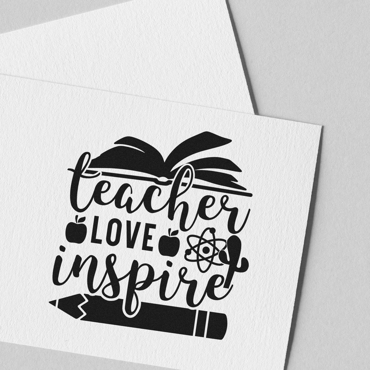 Black teacher-themed stamp/seal design on white paper with apple, atom and pencil icons, reading teacher love inspire