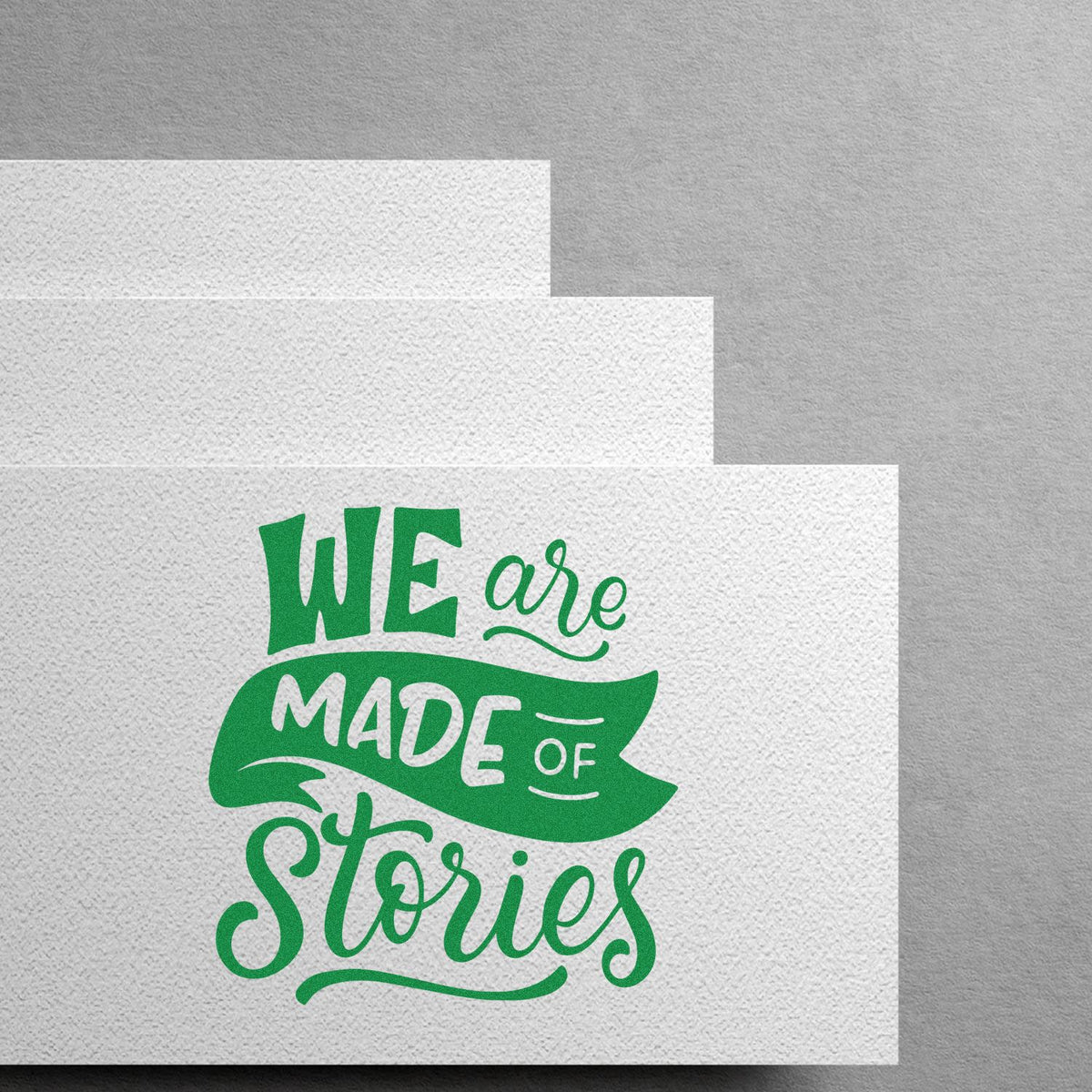 Green stamp and seal design on textured white paper reading We are made of stories.