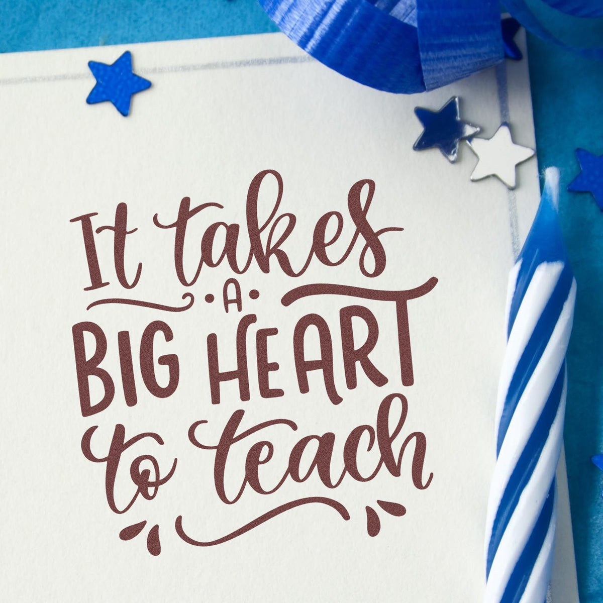 Burgundy teaching stamp on cream card with blue star seal stickers and blue ribbon accents, reading It takes a big heart to teach