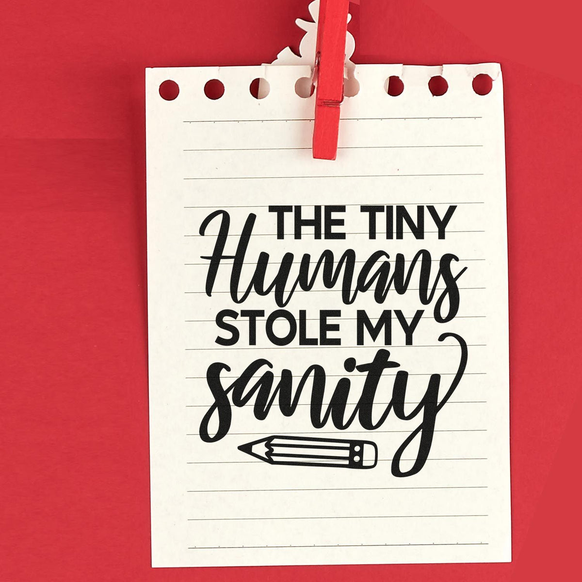 White notepad-style stamp and seal with red clip on red background, reading The Tiny Humans Stole My Sanity with a pencil icon.
