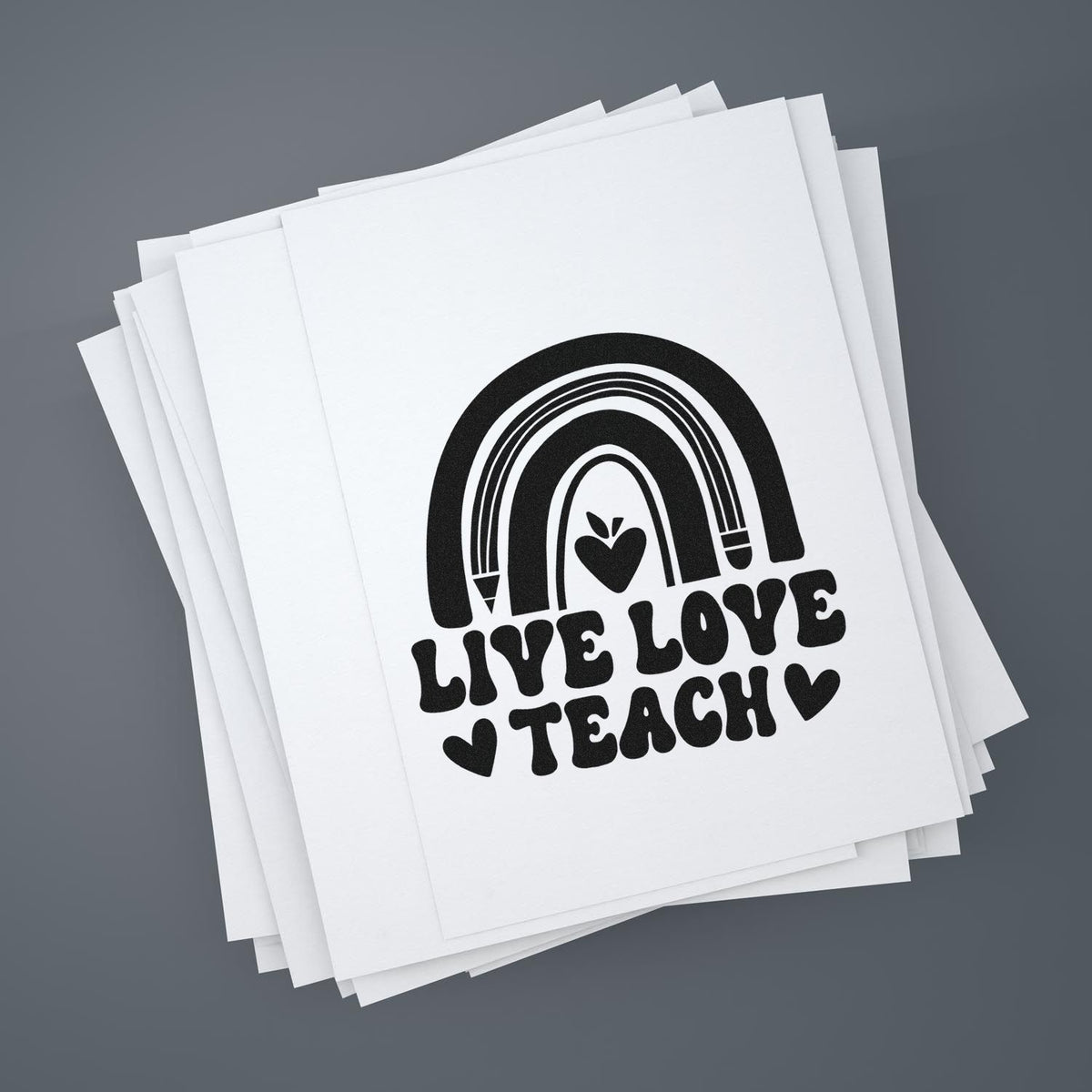Stack of white paper sheets featuring a black Live Love Teach rainbow heart stamp and seal design.
