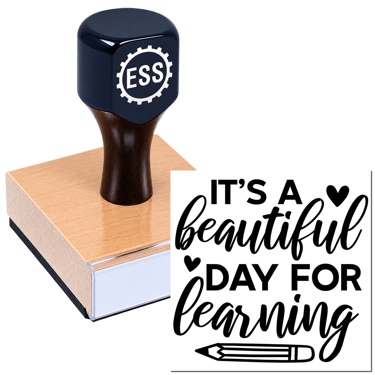 Dark blue ESS rubber stamp seal on wooden block with "It's a beautiful day for learning" and pencil graphic.
