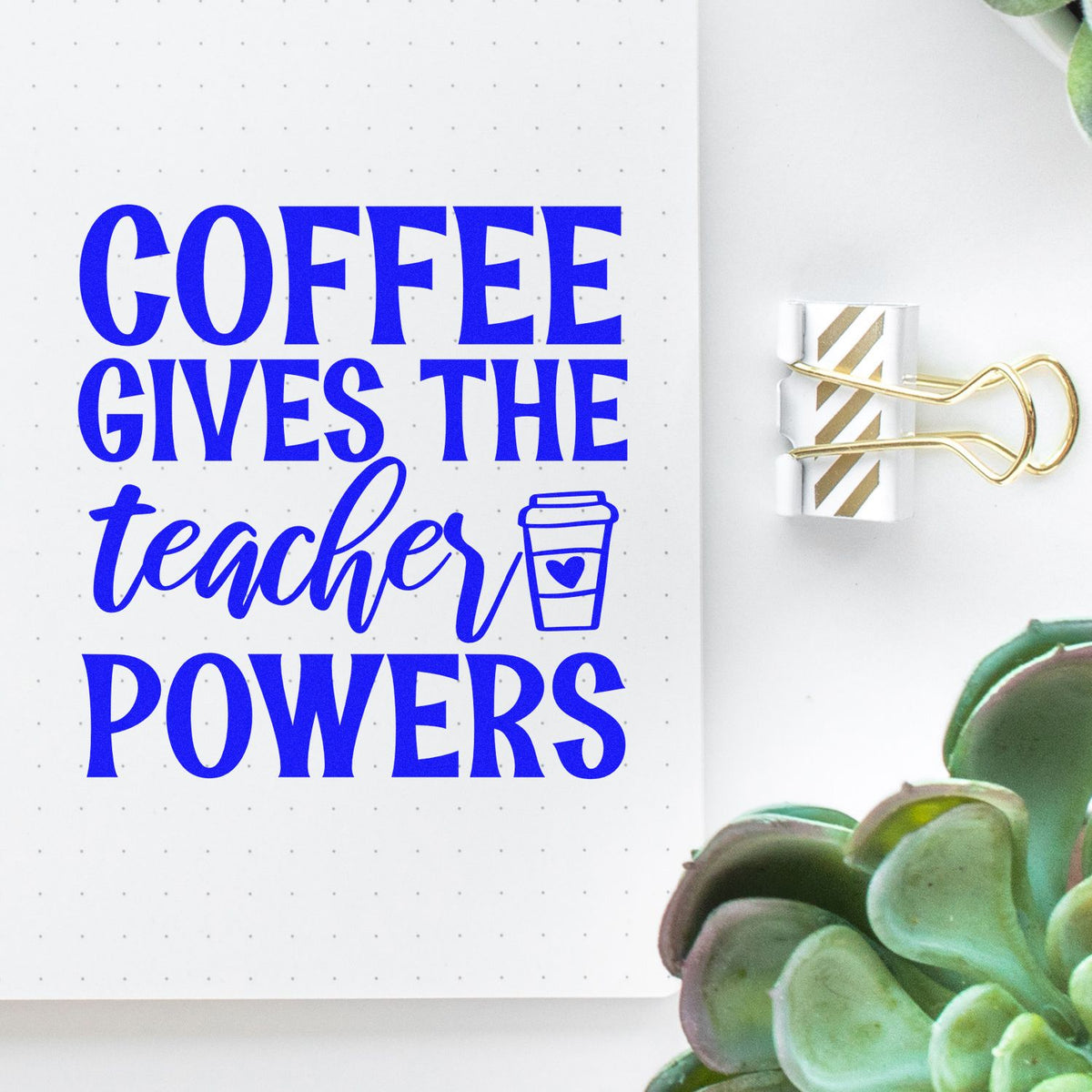 Blue coffee-teacher powers slogan on white dotted notebook, clipped with gold-striped stamp seal and gold binder clip.