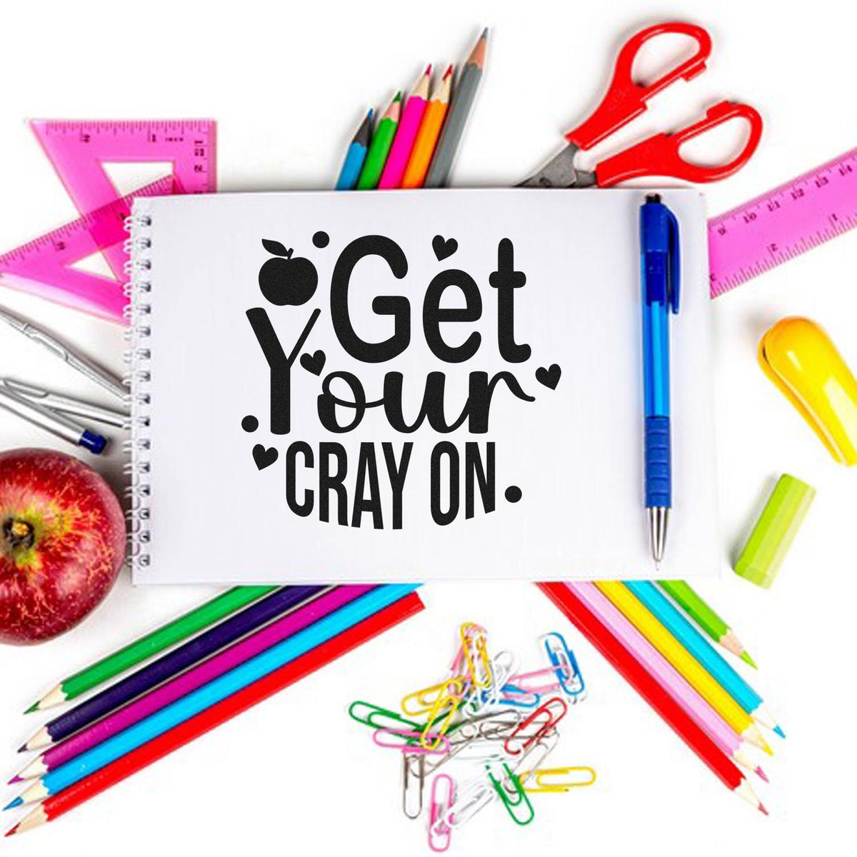 Custom stamp and seal with black Get Your Crayon text on white paper, surrounded by colorful pencils and school supplies.