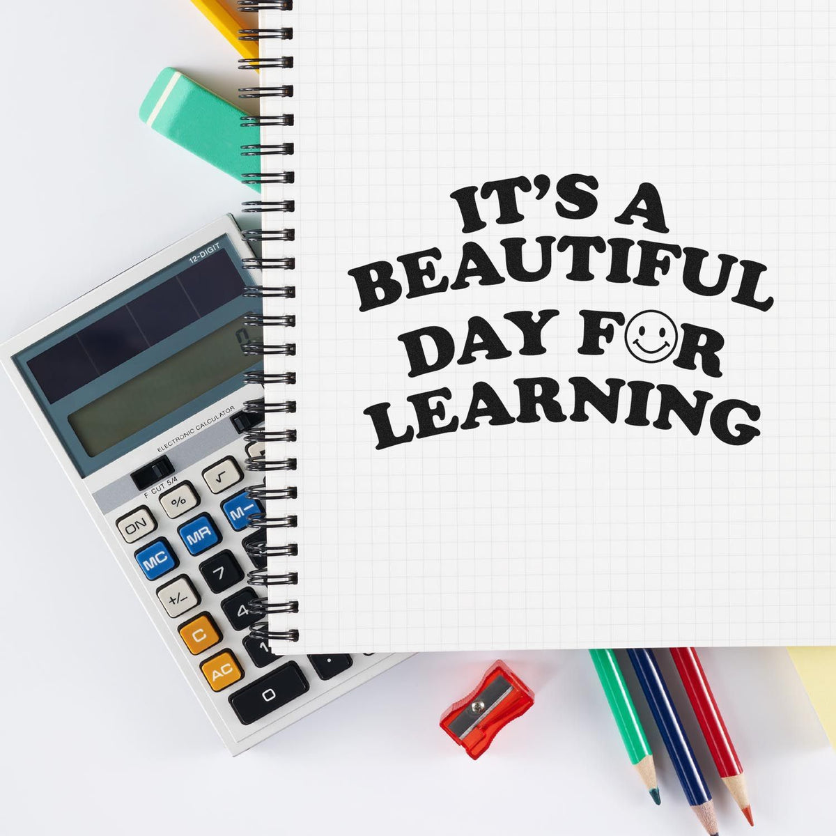 Learning-themed stamp and seal design on a grid notebook, with black quote, calculator, pencils, green eraser, and sharpener.