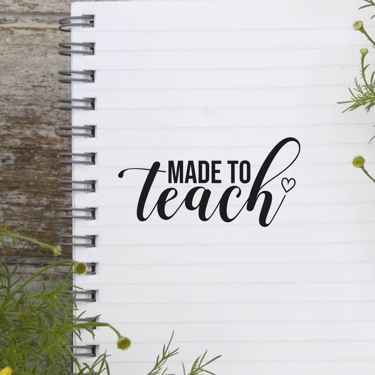 Black custom teacher stamp and seal on a white spiral notebook page with green floral accents.