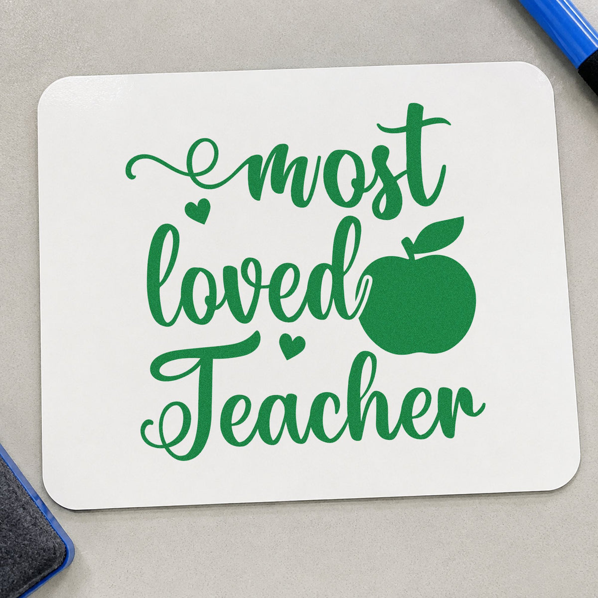 Most Loved Teacher Apple craft stamp imprint in green ink on a handmade project, one idea being signing sheet pages.