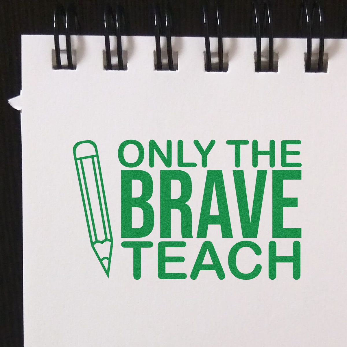 Green teacher stamp seal with pencil icon and bold Only the Brave Teach text on white spiral notepad.