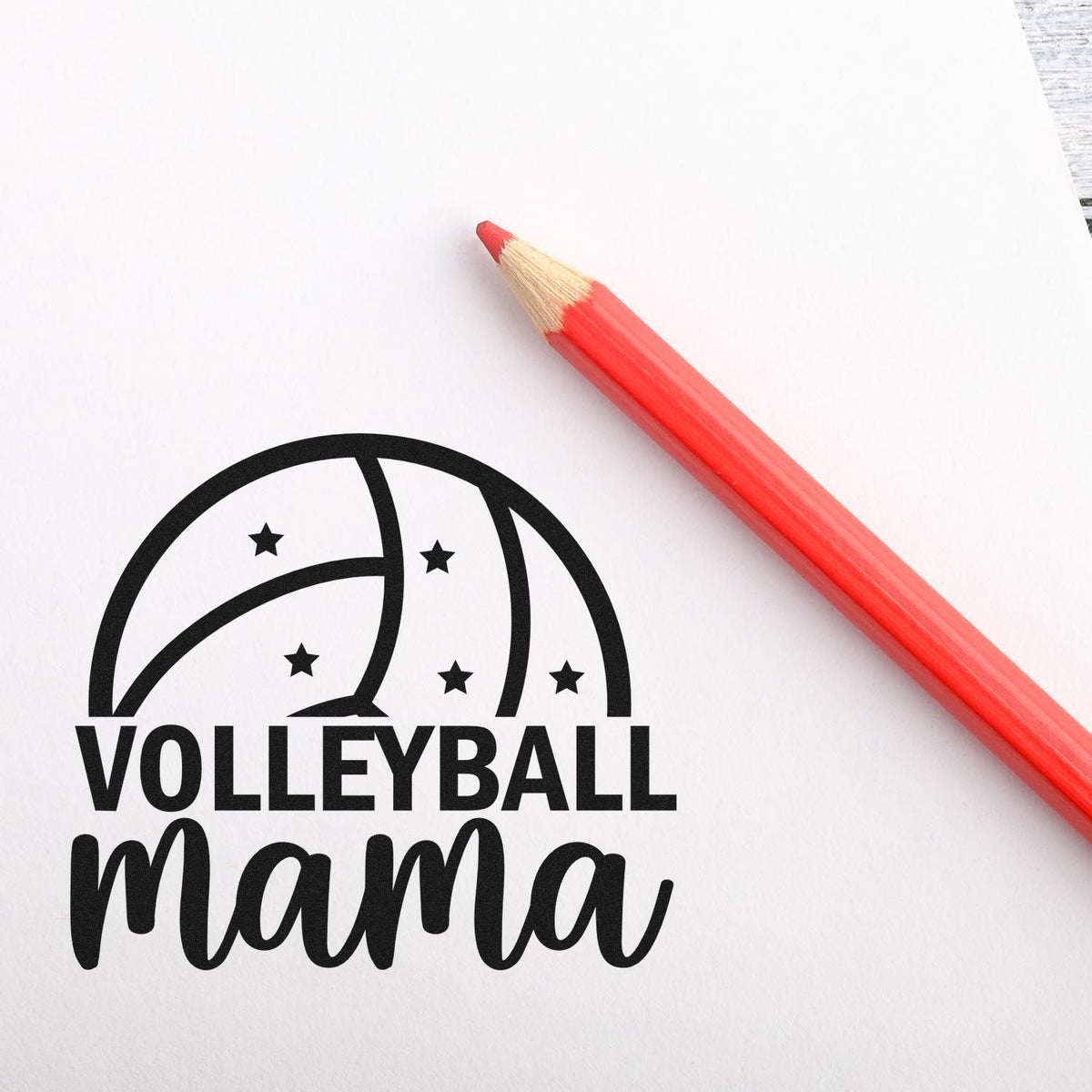 Black Volleyball Mama stamp seal with volleyball graphic and stars, paired with a red pencil on white paper.