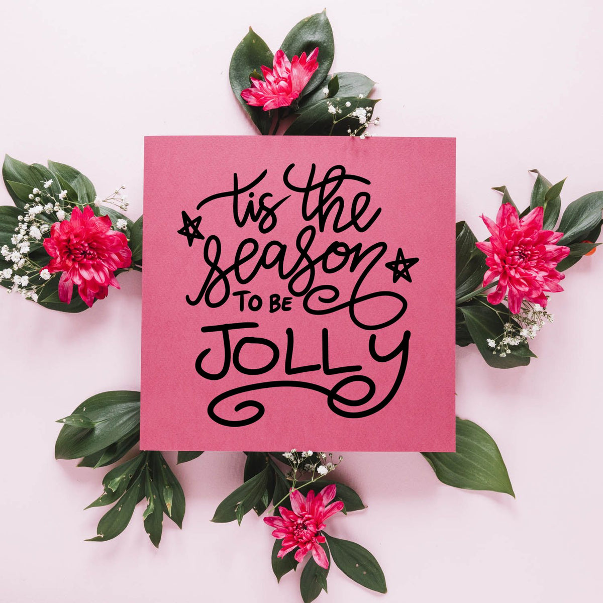 Pink stamp and seal product with black Tis the season to be jolly lettering, green leaves, and bright pink flowers.