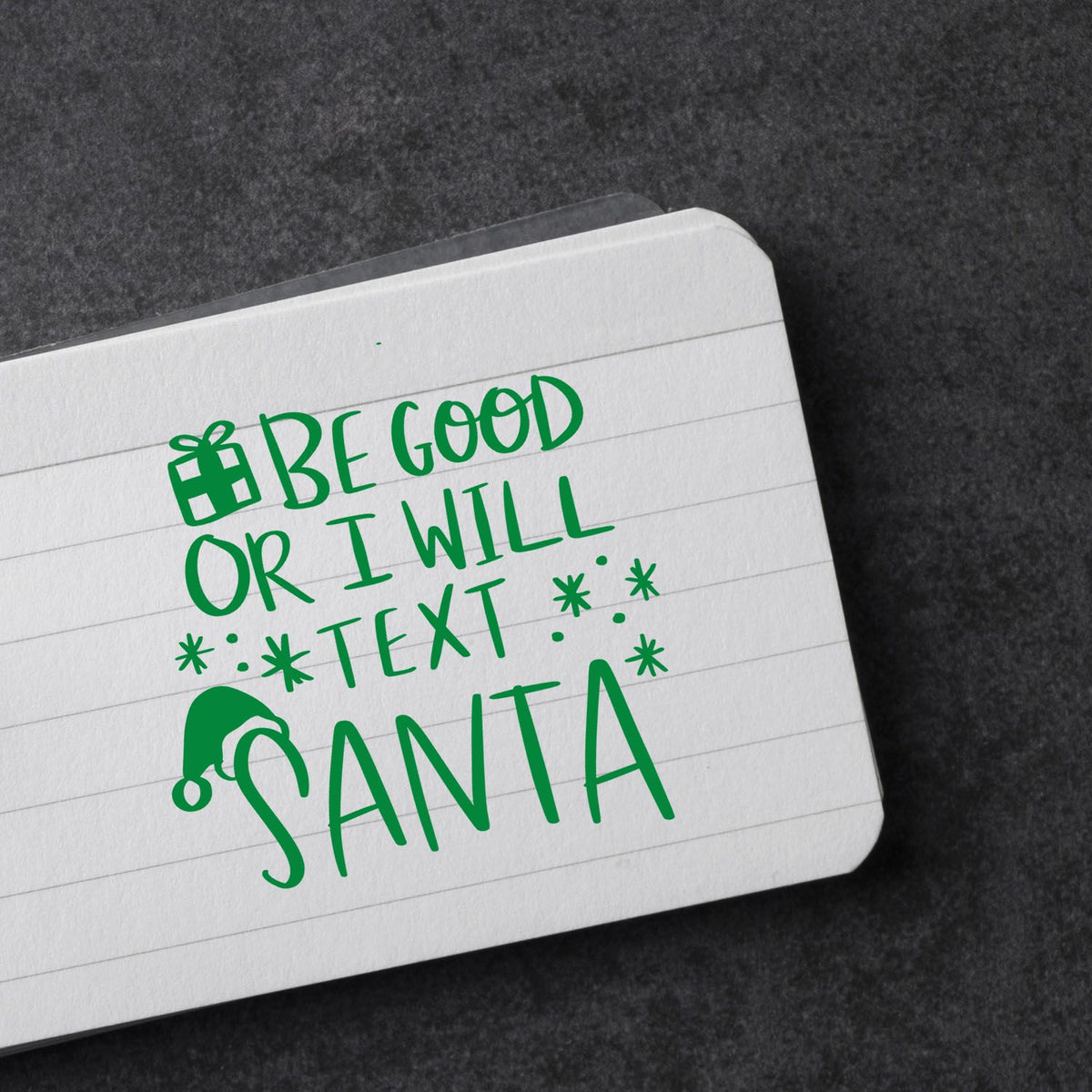 Green holiday stamp/seal design reading Be good or I will text Santa with gift and Santa hat icons on a white card.