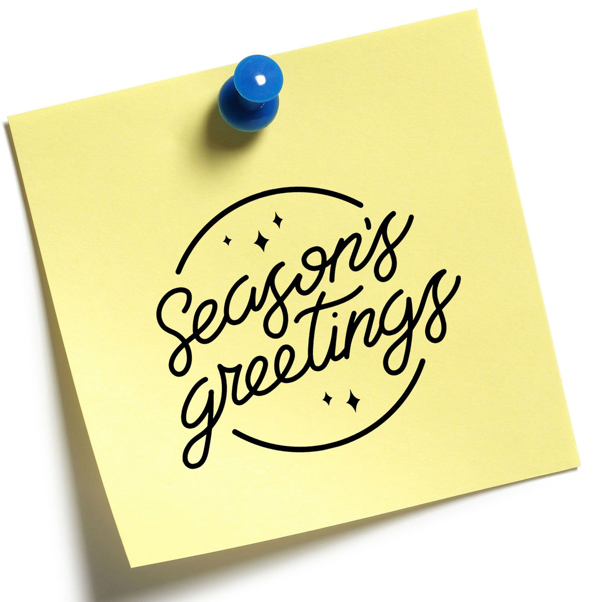 Yellow sticky note pinned with a blue pushpin, featuring a black Seasons Greetings stamp seal design.