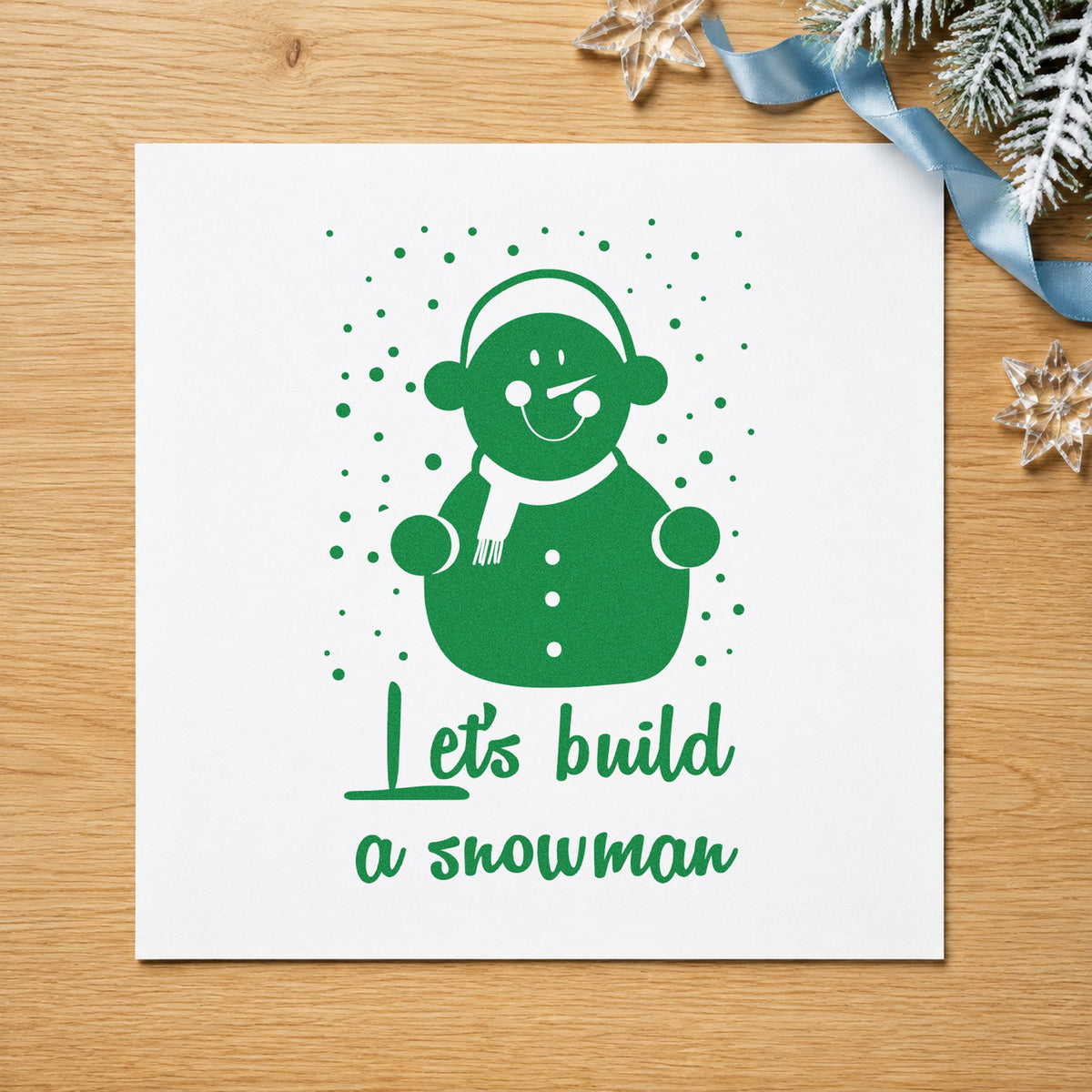 Let's Build A Snowman craft stamp imprint in green ink on a handmade project, one idea being winter plan pages.