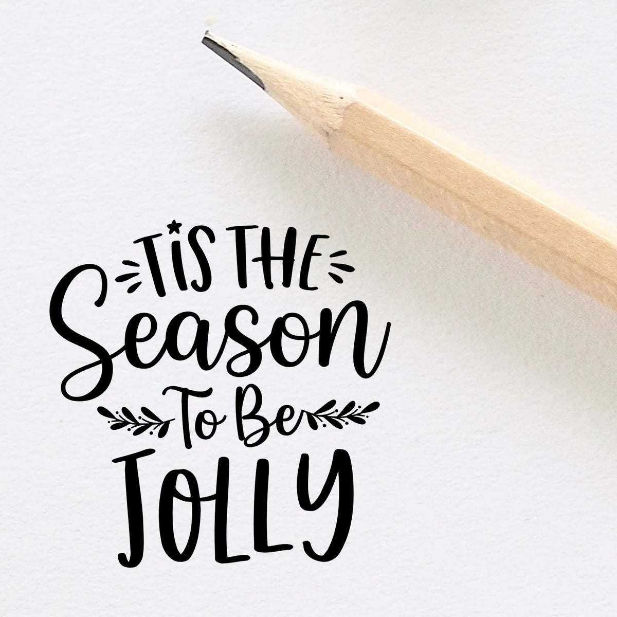Black holiday stamp and seal design reading Tis the Season to Be Jolly with decorative flourishes on white.