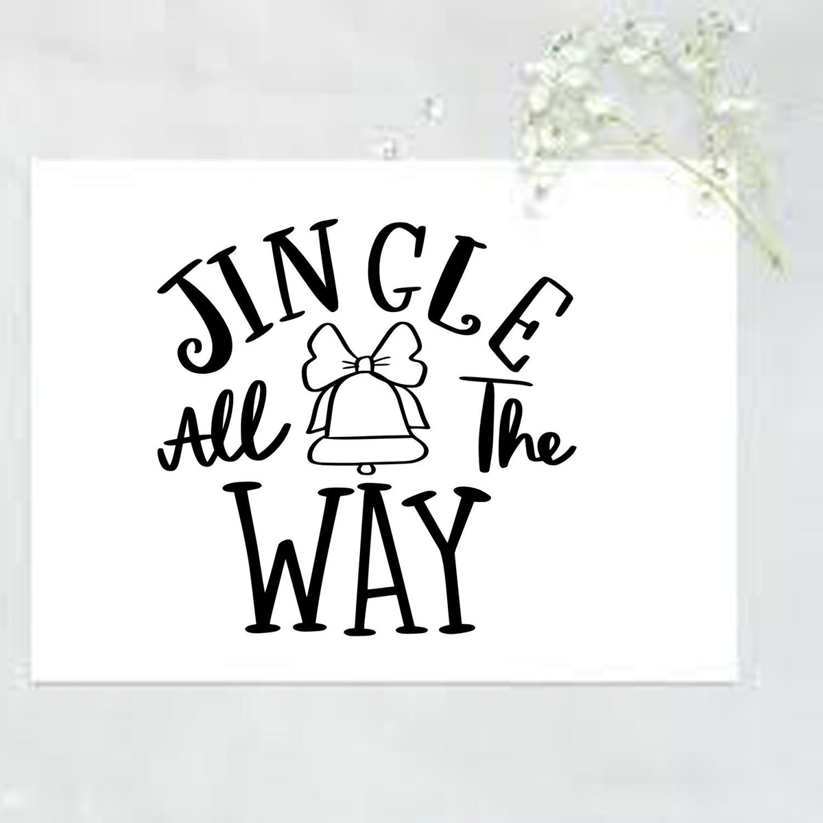 Black Jingle All the Way bell stamp and seal design with bow on a white card, ideal for holiday packaging.
