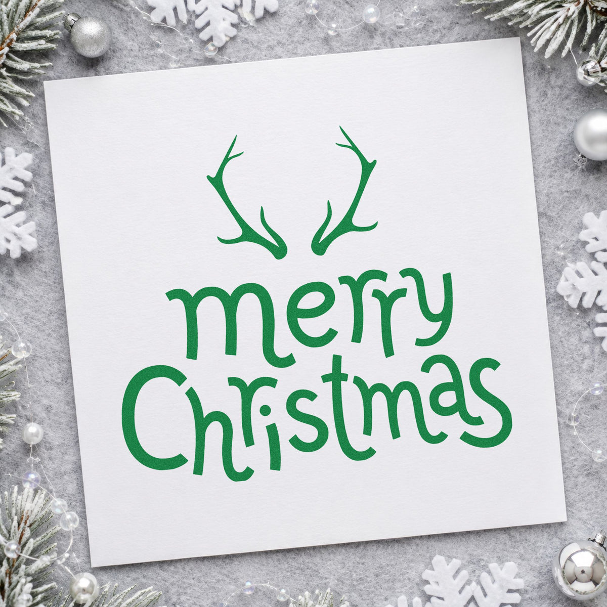 Merry Christmas Antlers craft stamp imprint in green ink on a handmade project, one idea being reindeer food bags.