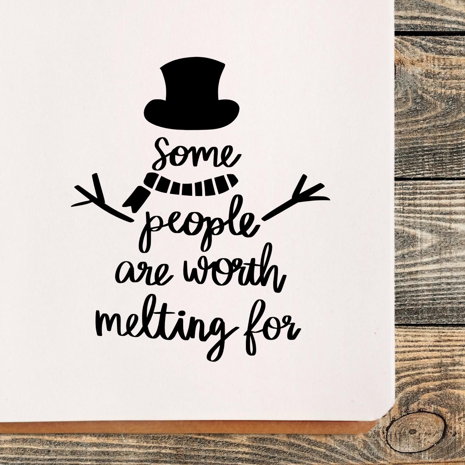 Black snowman stamp design with top hat, scarf and branch arms, reading Some people are worth melting for on white background.