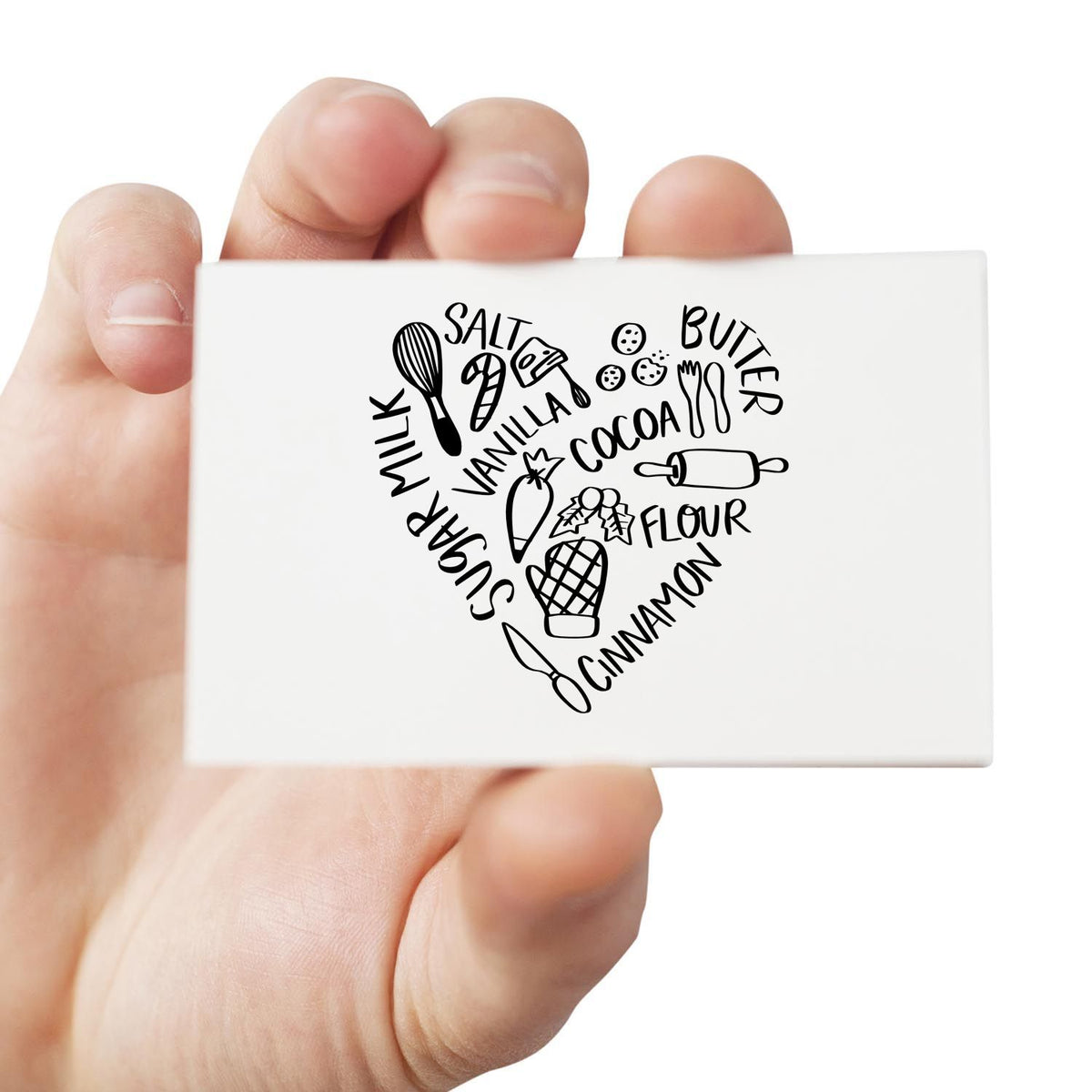 Handheld white rubber stamp seal with black heart-shaped baking ingredients, utensils, and words like salt, butter, flour, cinnamon.