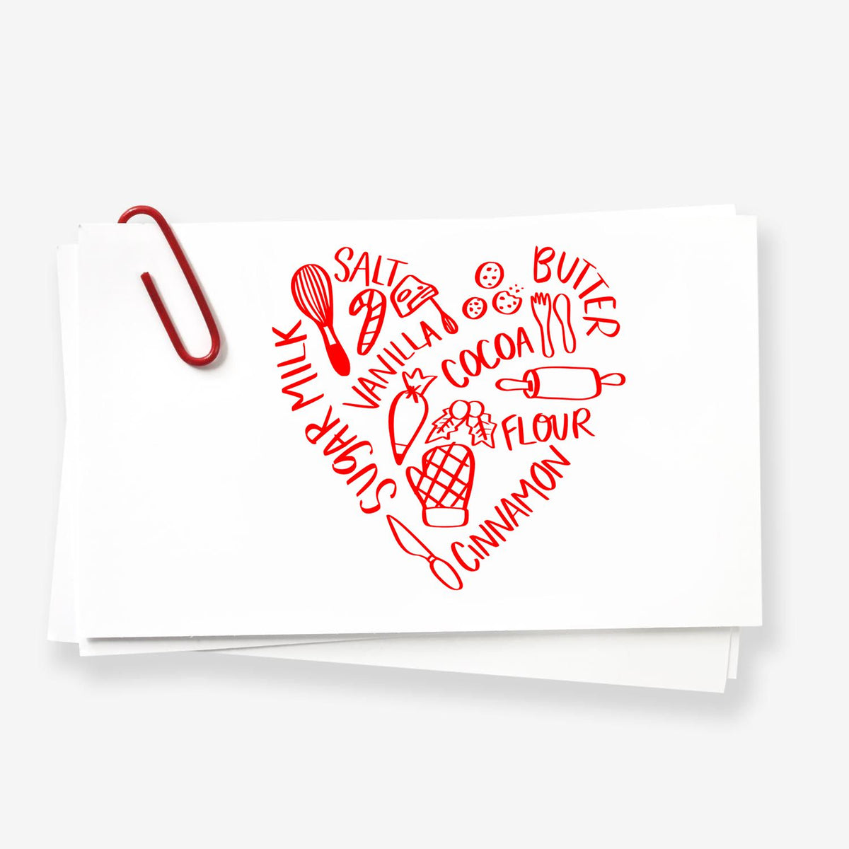 Red stamp and seal on white cards, forming a heart of baking words and utensils with a red paperclip.