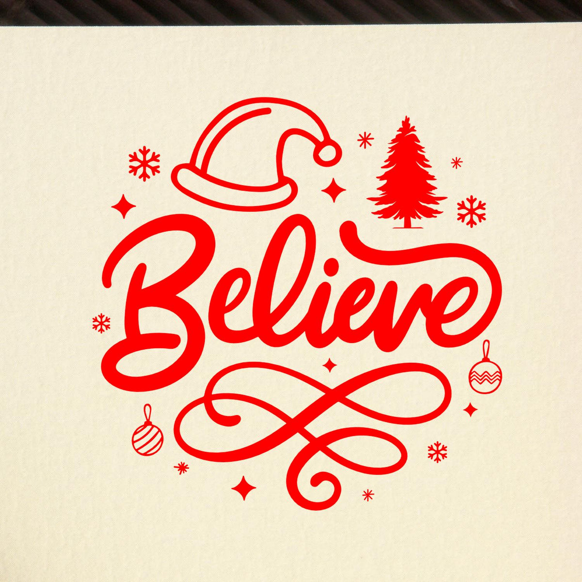 Red holiday stamp seal reading Believe with Santa hat, Christmas tree, ornaments, and snowflakes on beige background.