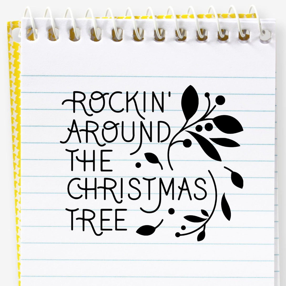 Black Christmas stamp and seal design on lined notebook paper, reading Rockin Around the Christmas Tree with floral flourish.