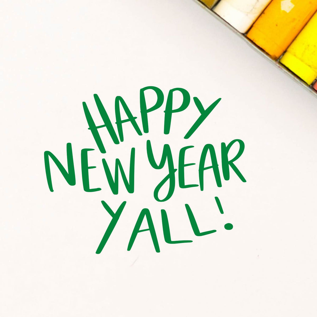 Green Happy New Year Yall stamp on white paper, with yellow and white seal blocks in the corner.