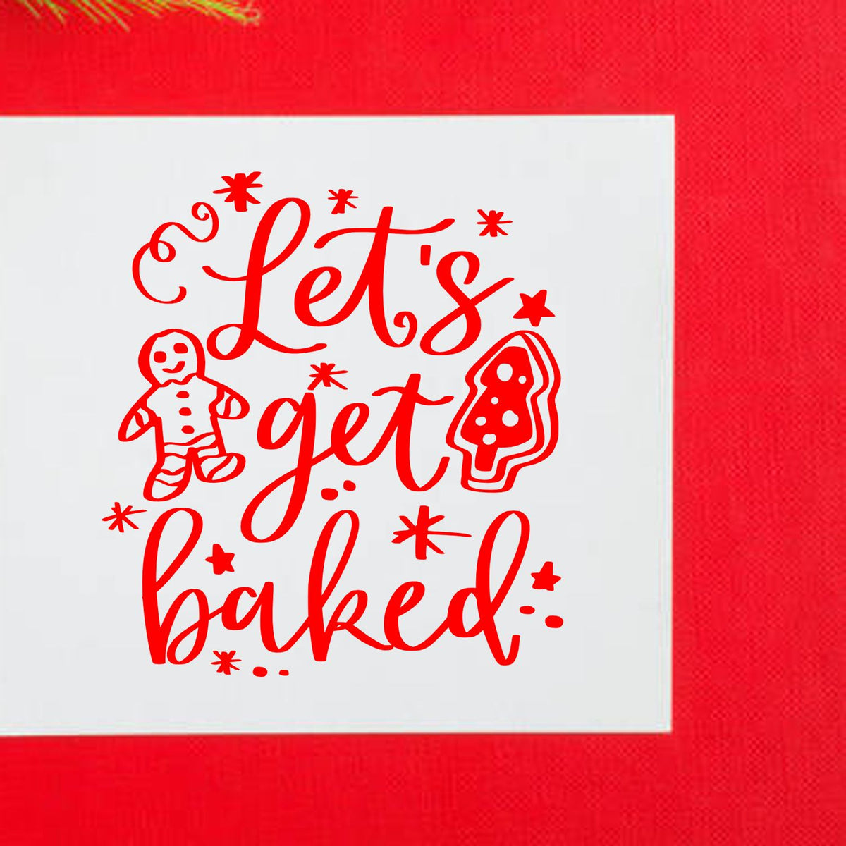 Festive red stamp/seal reading Lets get baked with gingerbread man and cookie tree on a white square, on a red background.