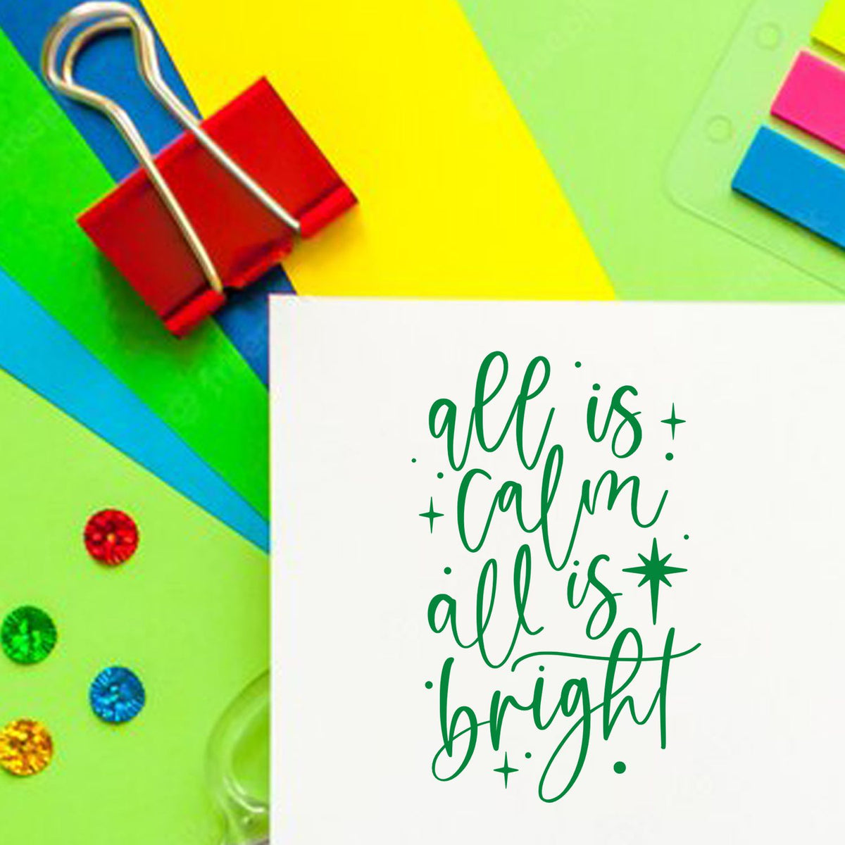 Green all is calm, all is bright stamp design with colorful stationery, paper clips, and seal embellishments.
