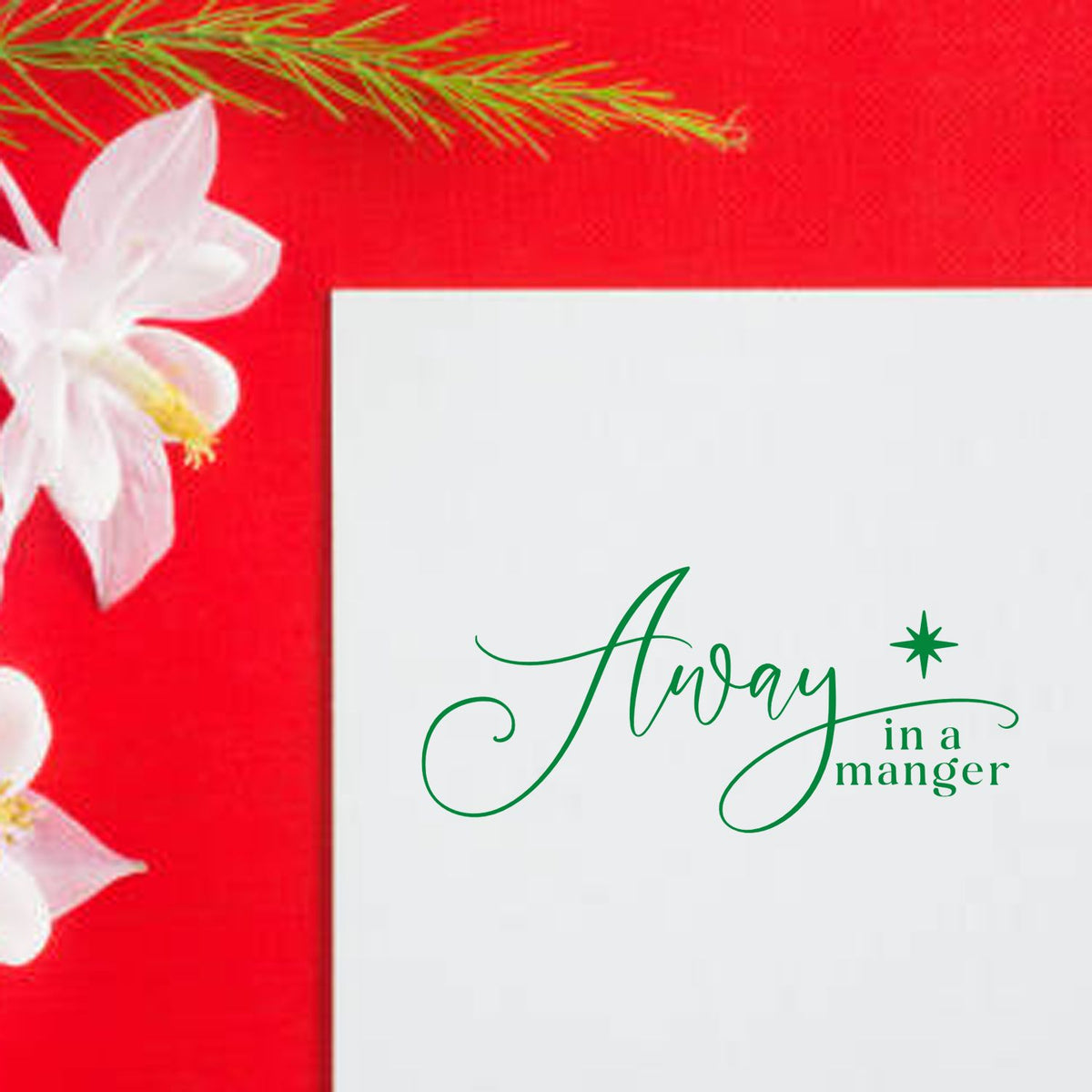 Green Away in a manger stamp/seal on a white card with red background and white flowers.