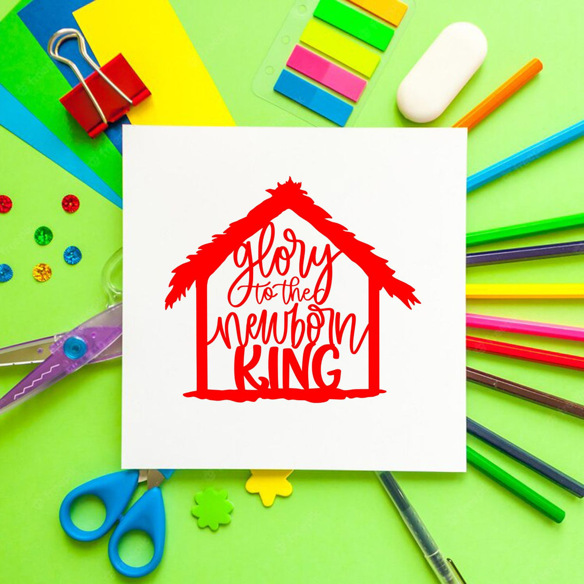 Red house-shaped stamp and seal design reading Glory to the Newborn King on white paper, surrounded by colorful stationery.