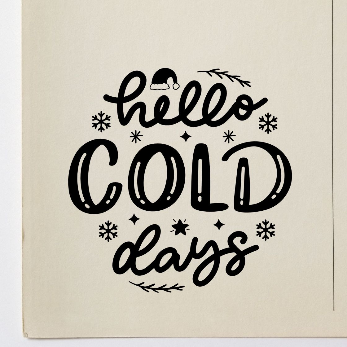 Black holiday stamp/seal reading hello cold days with snowflakes and branches on cream paper.
