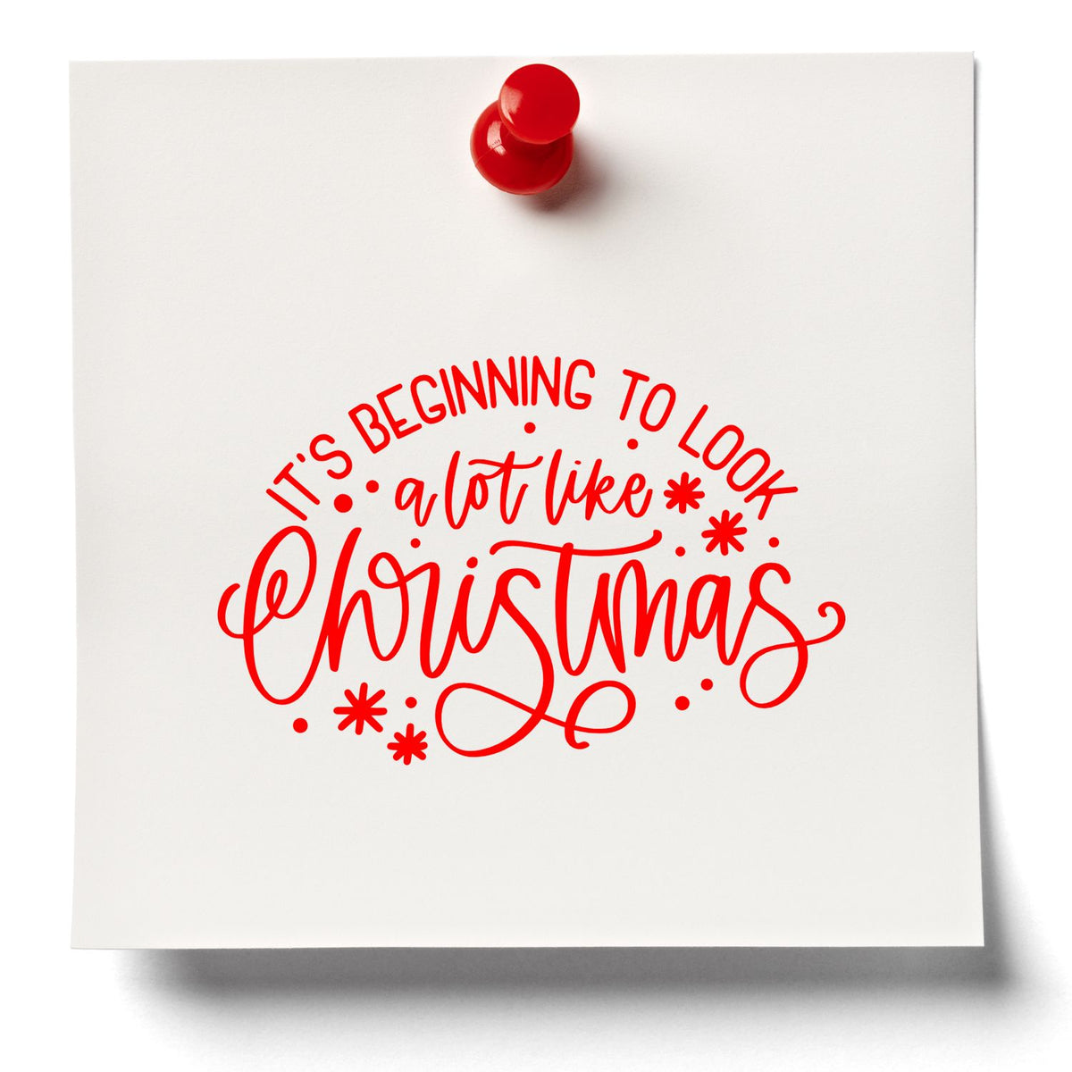 Red stamp and seal on white paper with Its Beginning to Look a Lot Like Christmas holiday lettering.
